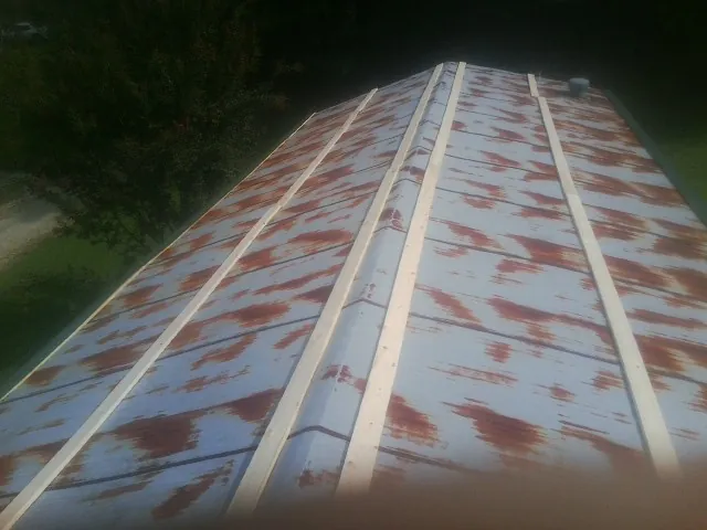 Rusted metal roof panels with new wood purlins before replacement — Storm Damage Roof Repair in Enderlin by Roofing Brothers